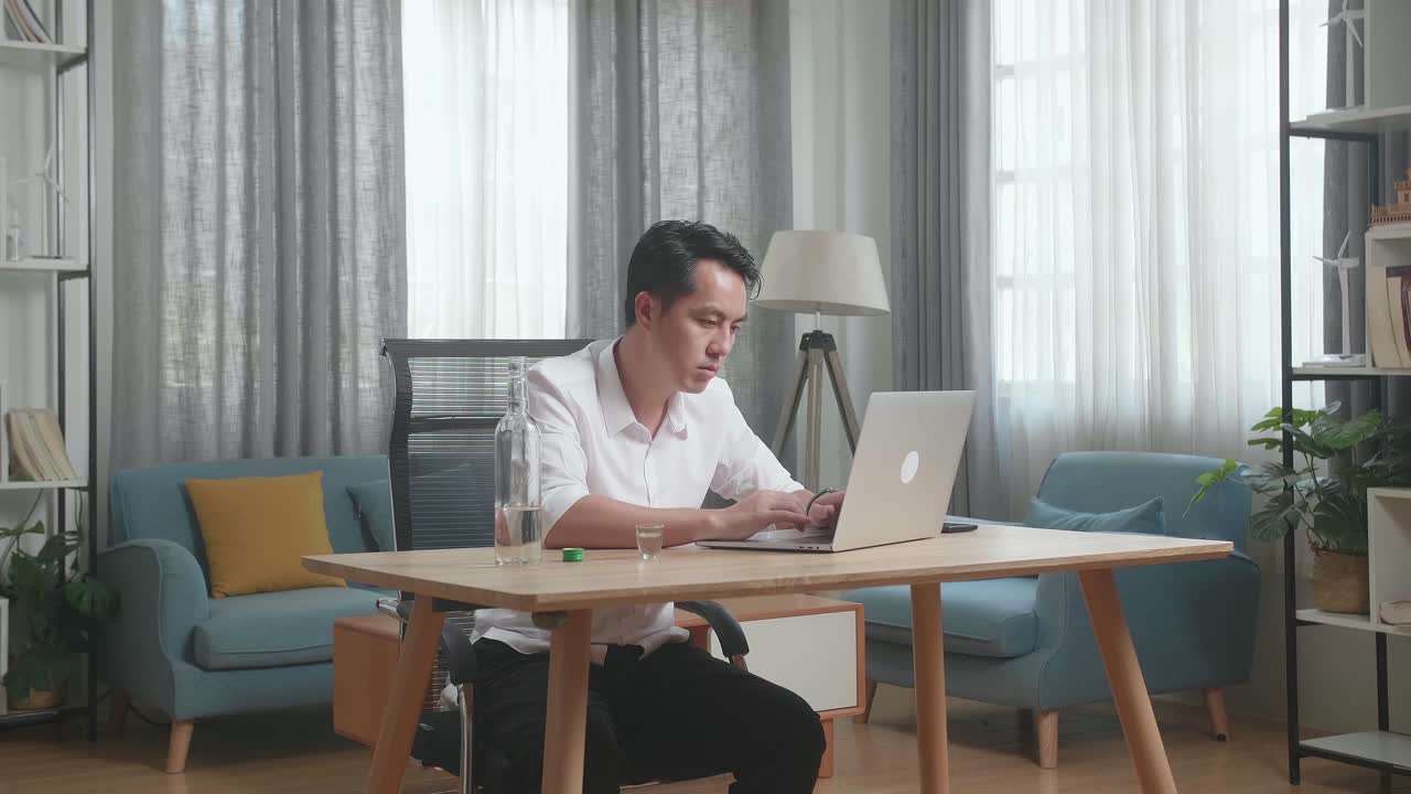 집에서 일하고 술을 마시는 남자