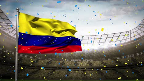 Animation-of-camera-flashes-and-confetti-falling-over-waving-colombia-flag-against-sports-stadium