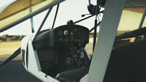 static-small-plane-cockpit-shot-whilst-panning-camera-movement-looking-threw-from-the-outside-wing-and-shell-of-the-white-plane-during-a-sunny-day