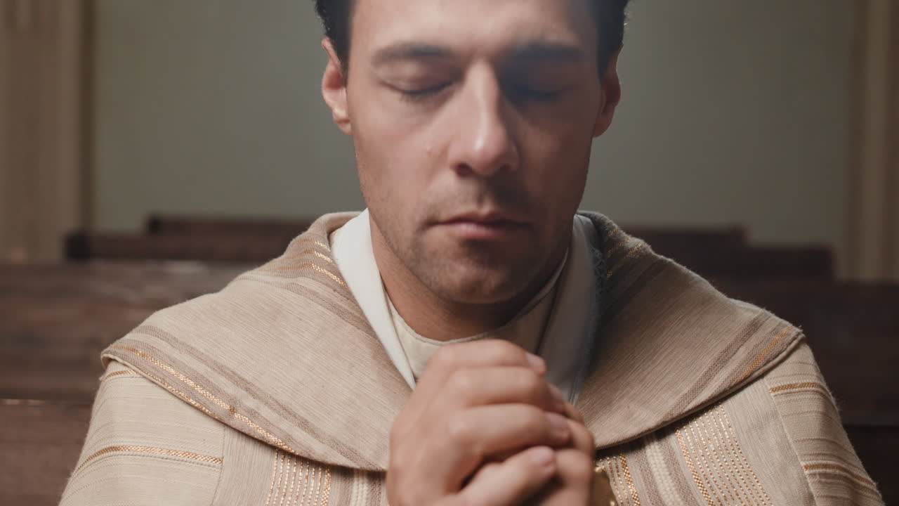 Priest praying with rosary