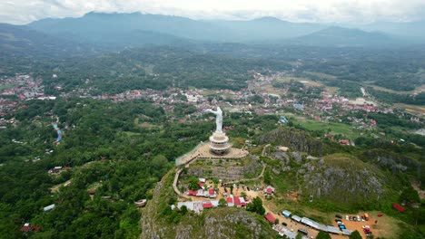 Aerial-of-a-Jesus-Christ-Statue-in-Tana-Toraja-Sulawesi-at-the-top-of-a-mountain-with-tourists-and-shops