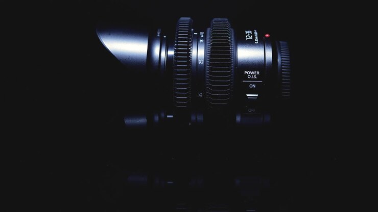 Film lens is artistically lit on a black background. Advanced optical technology.