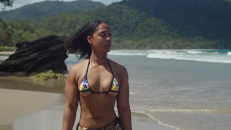 maravillarse de la dedicación al fitness de una chica de fitness vestida con bikini, caminando al aire libre en un paraíso de playa tropical
