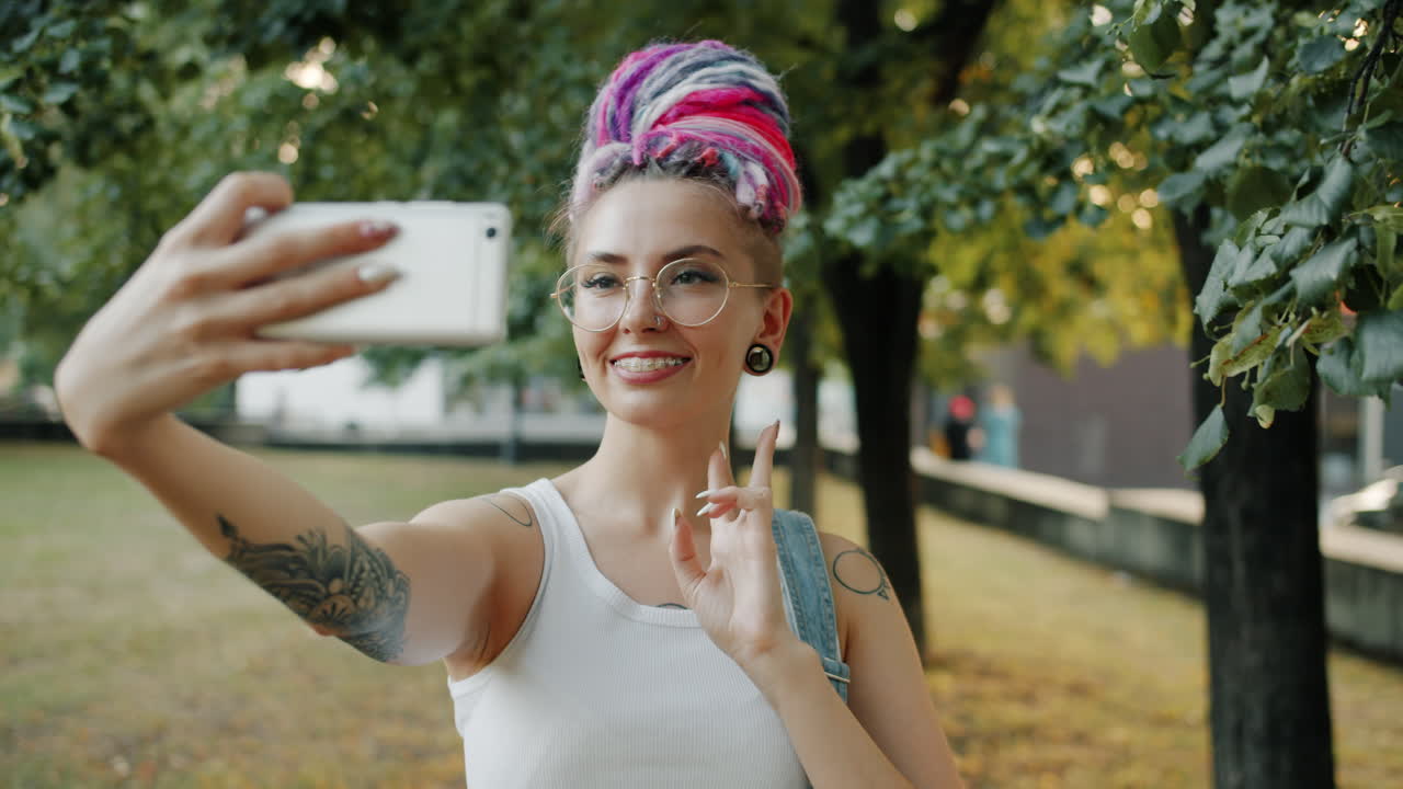 una mujer joven tomando una selfie en un parque.
