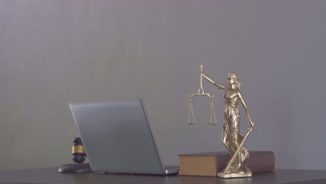 laptop judge hammer books and scales the goddess of justice on the lawyer's legal advisory concept table.