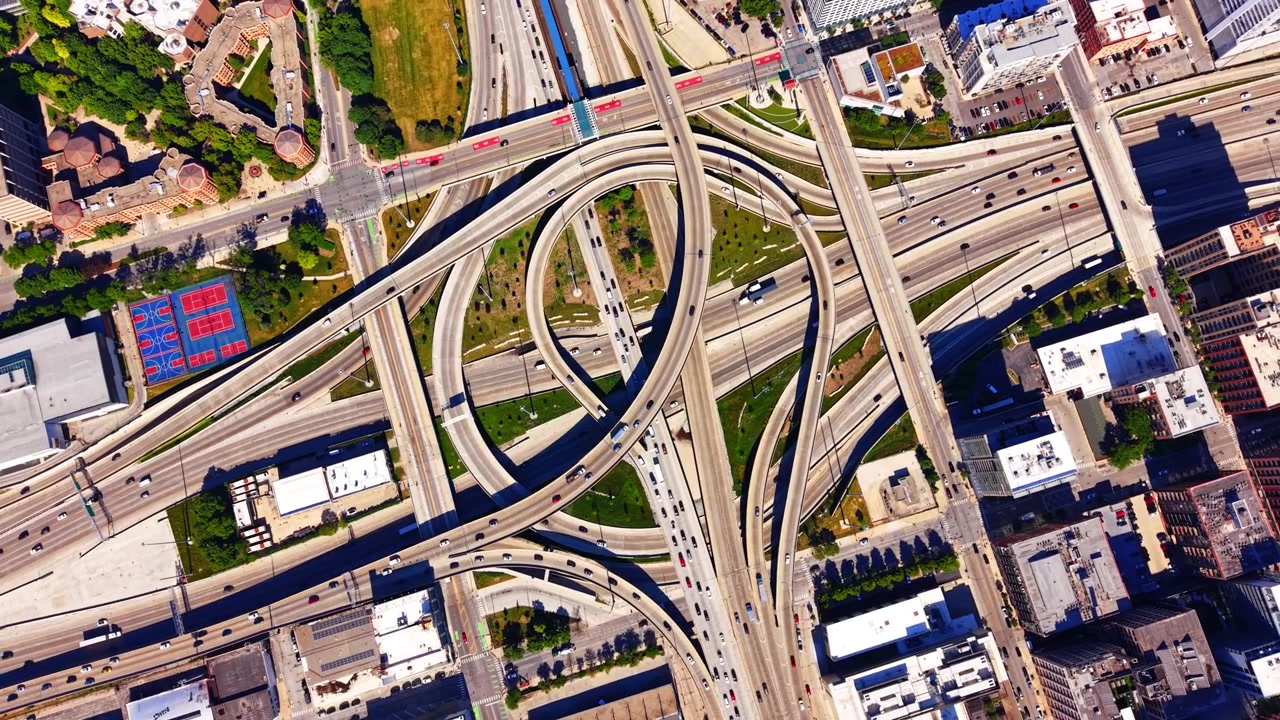 Aerial view of circular highway interchange i290 and i90, Chicago Illinois. Looping expressway ramps, sports courts and traffic lanes near the city center.
