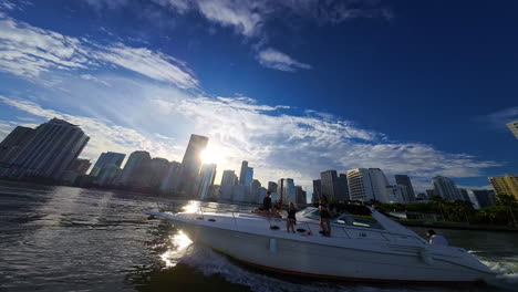 girls having a party, dancing on the moving yacht. skyline of american metropolis at backdrop. fpv drone footage.