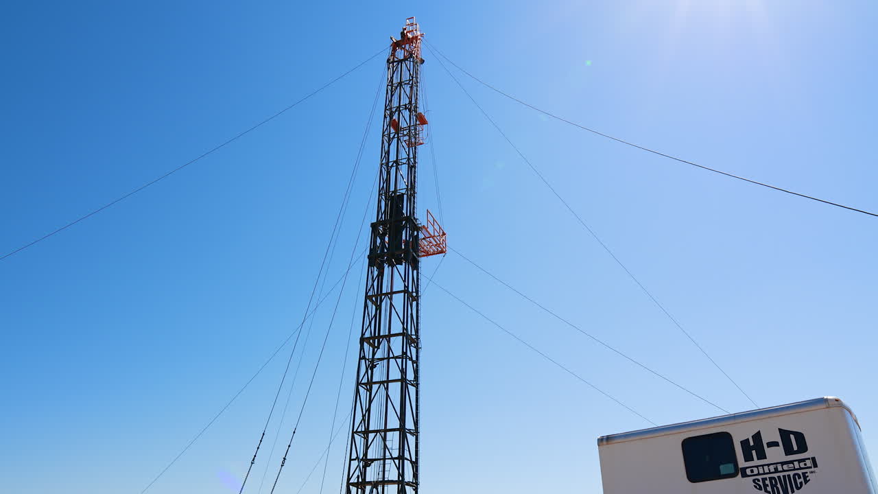Oil and gas drilling rig onshore in the wheat field. A truck with a derrick and wagon in the plantation.