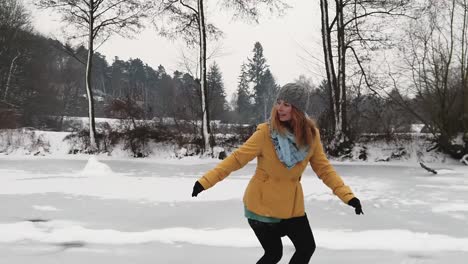 mujeres jóvenes de cabeza roja patinando sobre hielo hacia atrás en un lago congelado rural