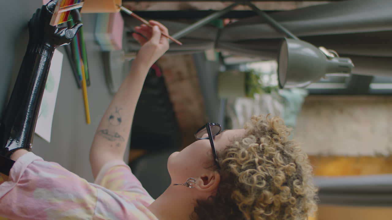 Woman with Prosthetic Arm Painting Picture with Watercolors