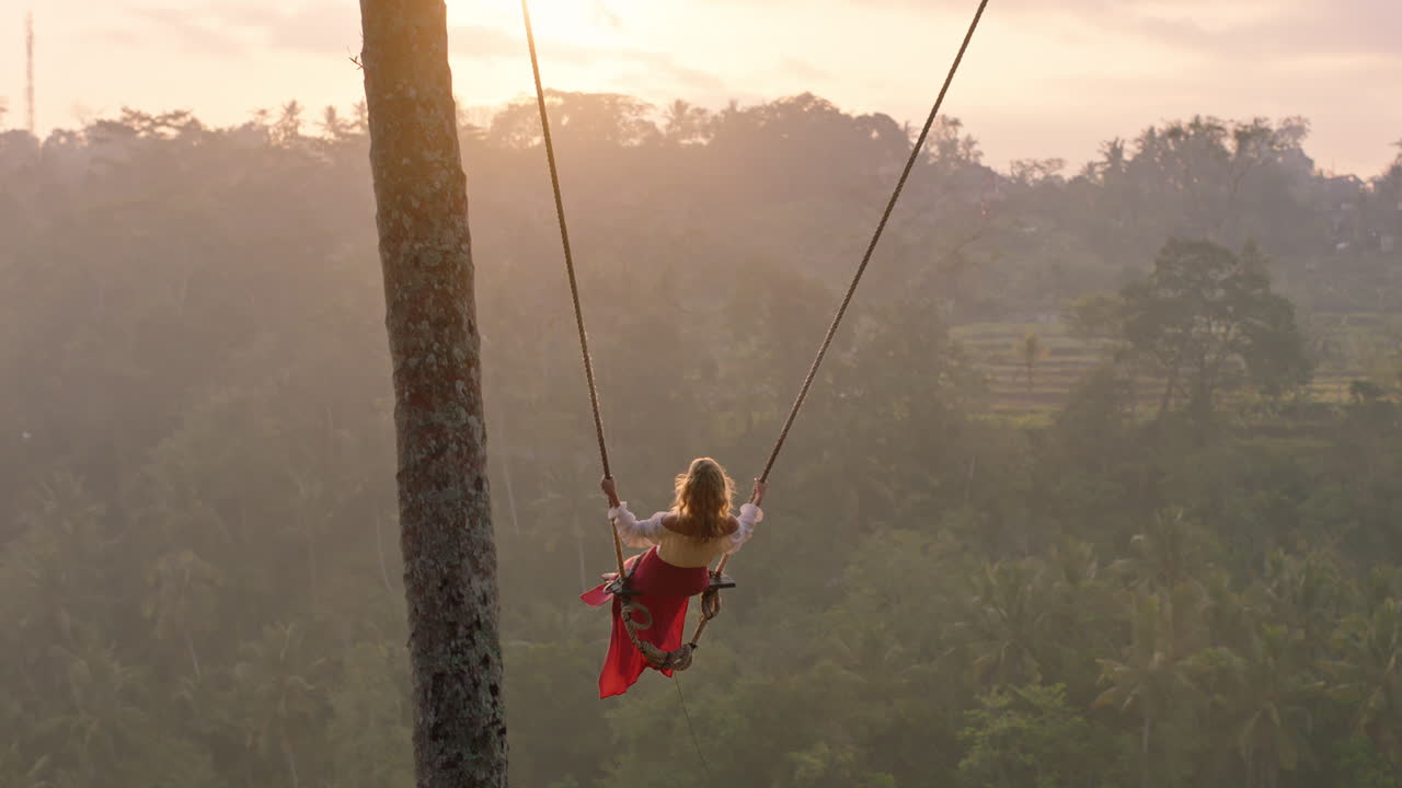 viaggiare donna oscillante sopra la foresta pluviale tropicale all'alba turista donna seduta sull'oscillazione con vista panoramica godendo della libertà in vacanza divertendosi stile di vita di vacanza rallentamento