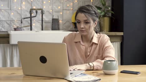 mujer trabajando en una computadora portátil en una cocina