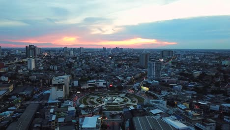 aerial view of city during sunset. flying over huge roundabout in bangkok, thailand