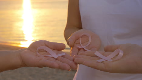 women with pink awareness ribbons outdoor at sunset