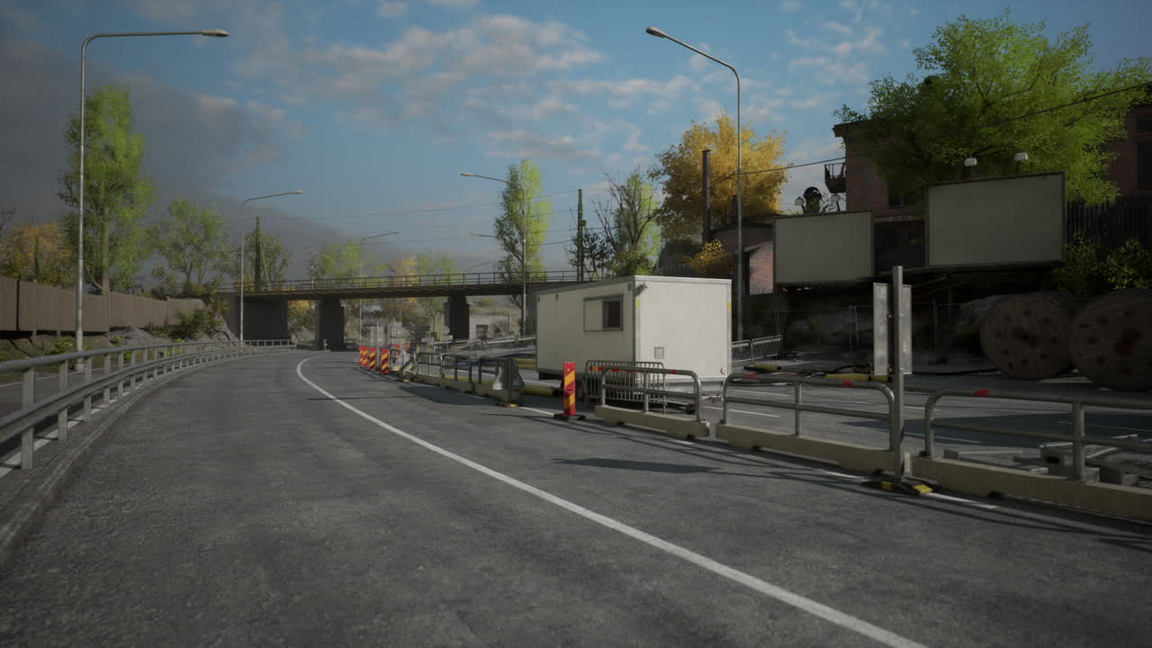 Construction site near roadway with barriers and workers visible in daylight