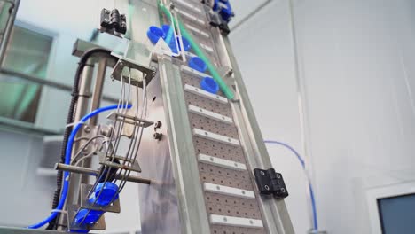 automatic technology in a dairy factory. modernized equipment in a plant. conveyor line rising up with plastic lids for further packaging. slow motion.