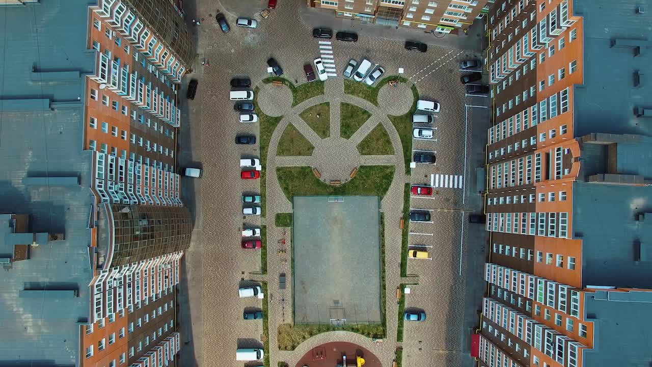 Top view of a modern district with car parking. New residential buildings with car parking and children playground. Aerial shot.