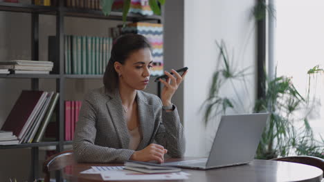 Woman-holding-smartphone-device-using-voice-recognition-function-recording-audio-message-or-talking-with-mobile-assistant.-Authentication-communication-online-technology-concept.