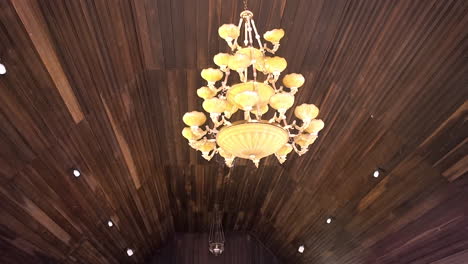chandelier hangs from the wooden roof of a dayak longhouse in borneo.
