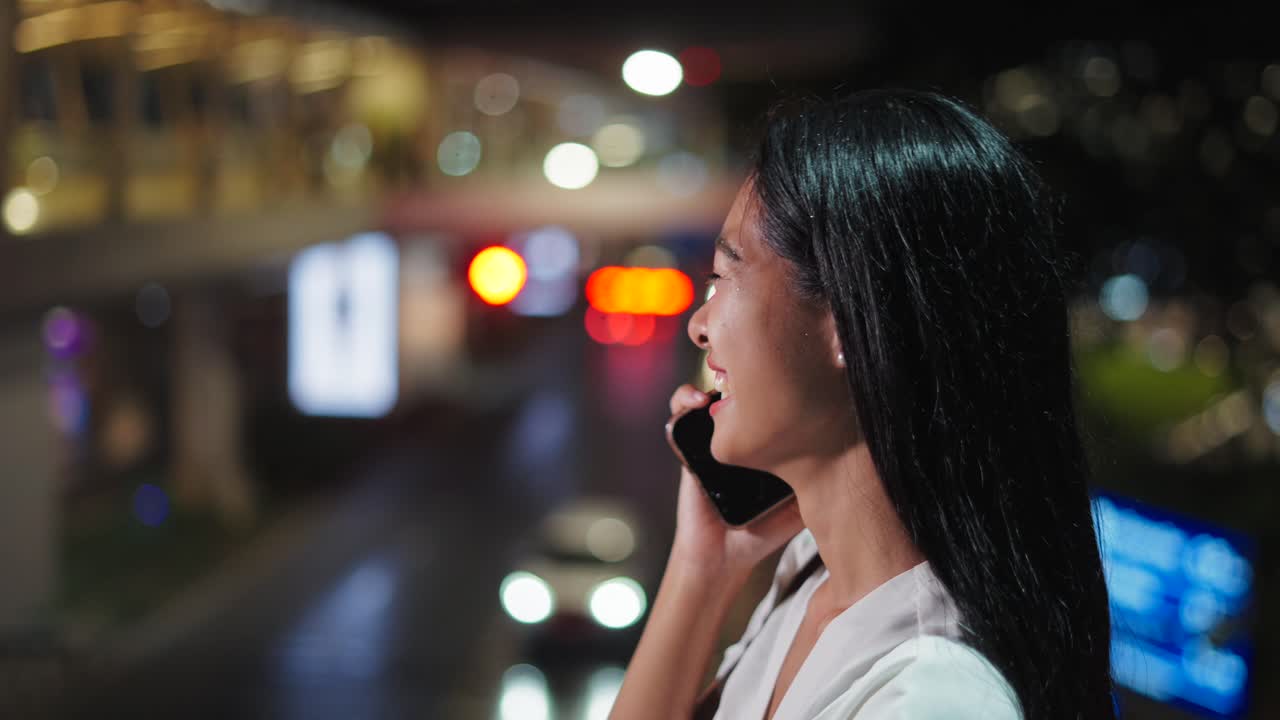 Woman talking on the phone at night in city
