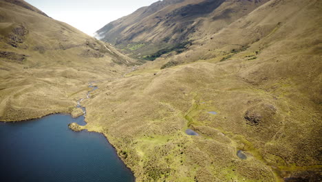 drone volando sobre las montañas de los andes y el lago en el parque nacional cajas, ecuador