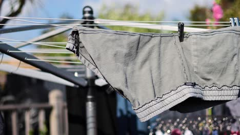 los pantalones se secan en una cuerda de ropa rotativa