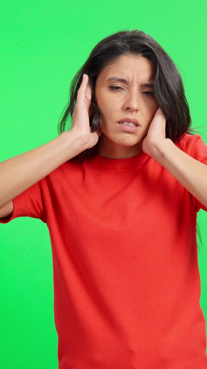 Donna angosciata che si copre le orecchie dal rumore forte su schermo verde