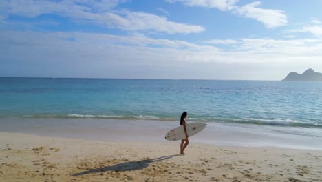 female surfer with surfboard walking in the beach 4k