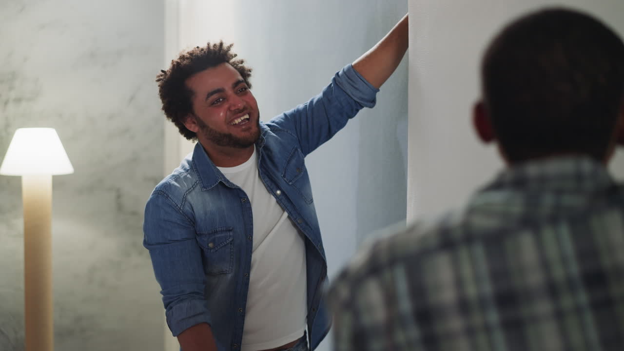 Black man laughs discussing wallpaper style with friend