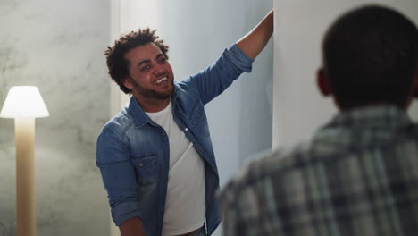 black man laughs discussing wallpaper style with friend