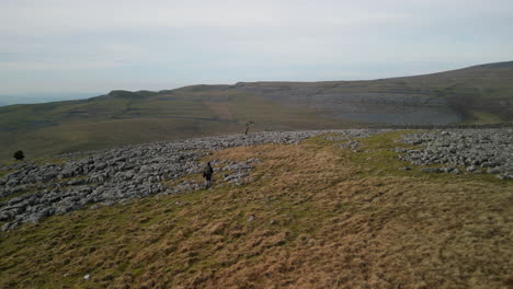 flying over hiker on moorland with reveal of green valley at ingleton yorkshire uk