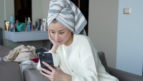 woman relaxing at home, using a smartphone