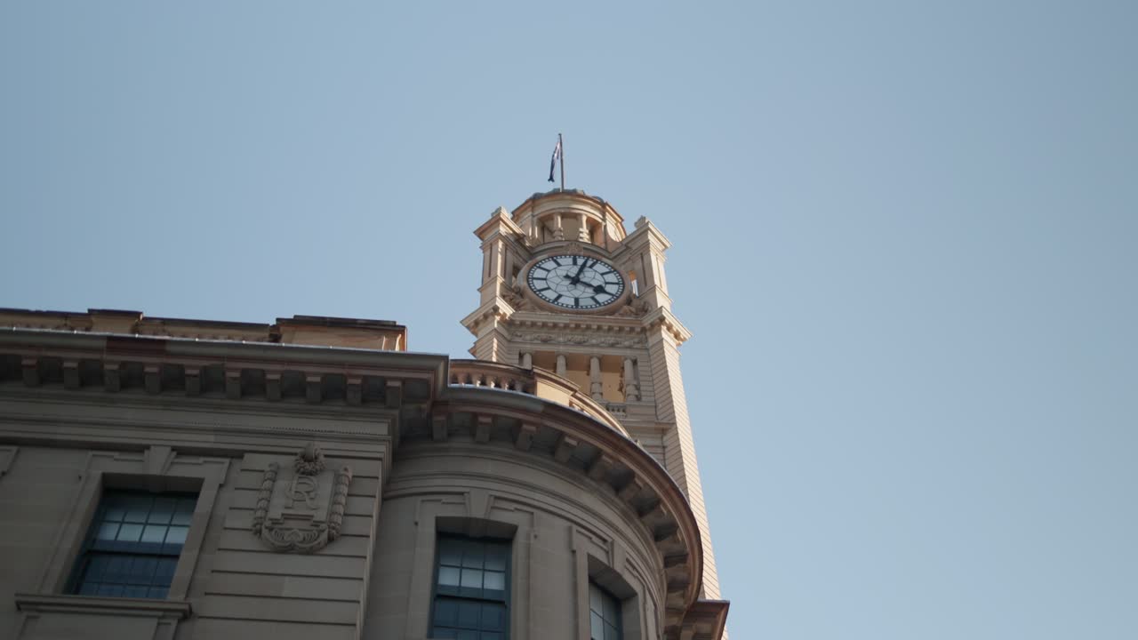 Slow motion side view of Sydney’s Central Station clock tower under a blue sky