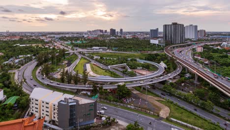 highway interchange junction and traffic during rush hour at bangkok outskirt, at evening twilight, day to night - time lapse