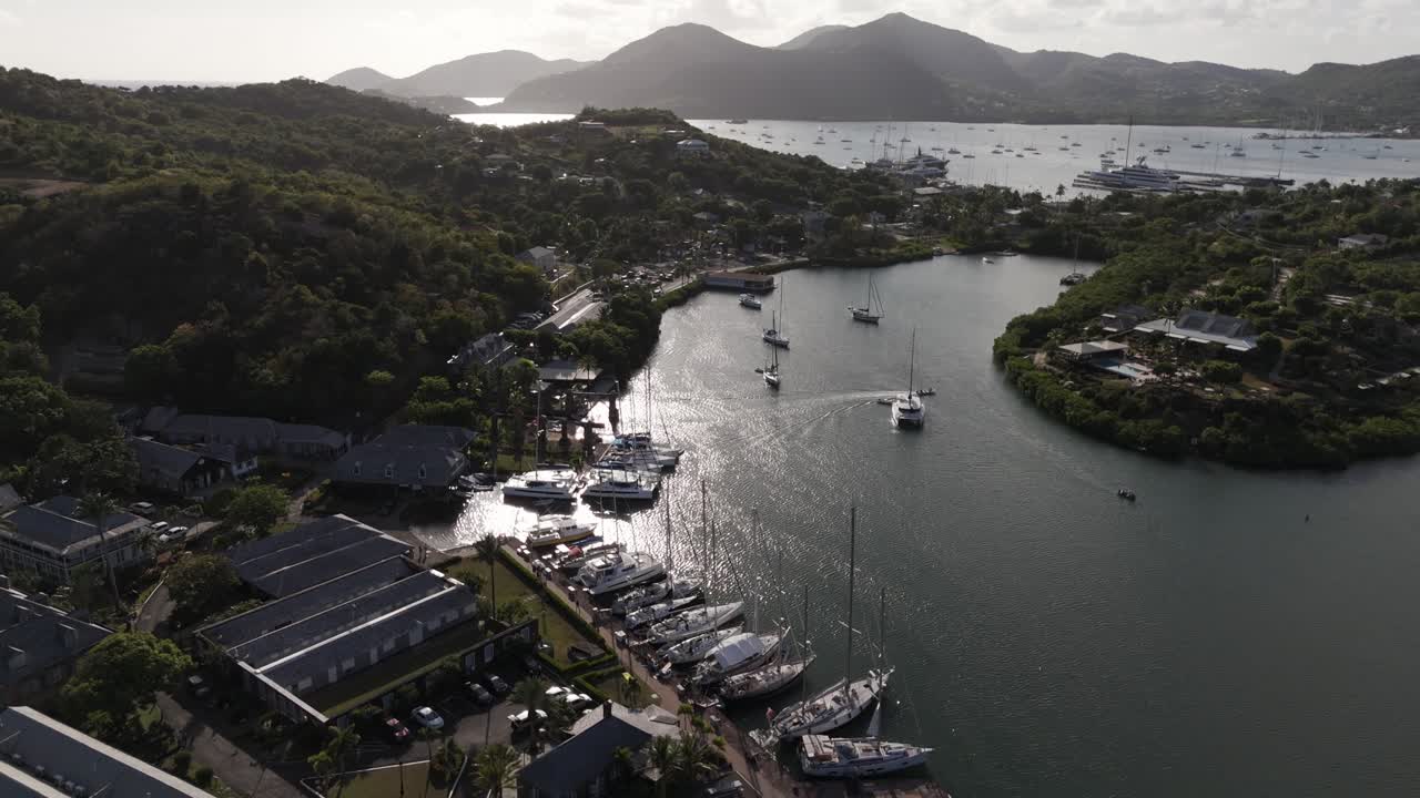 English Harbour in Antigua seen from above with boats docked, calm water, and lush green hills