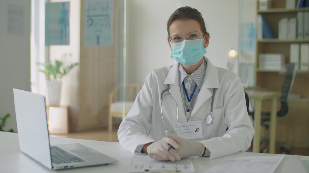 Dottoressa con mascherina che parla alla telecamera in clinica