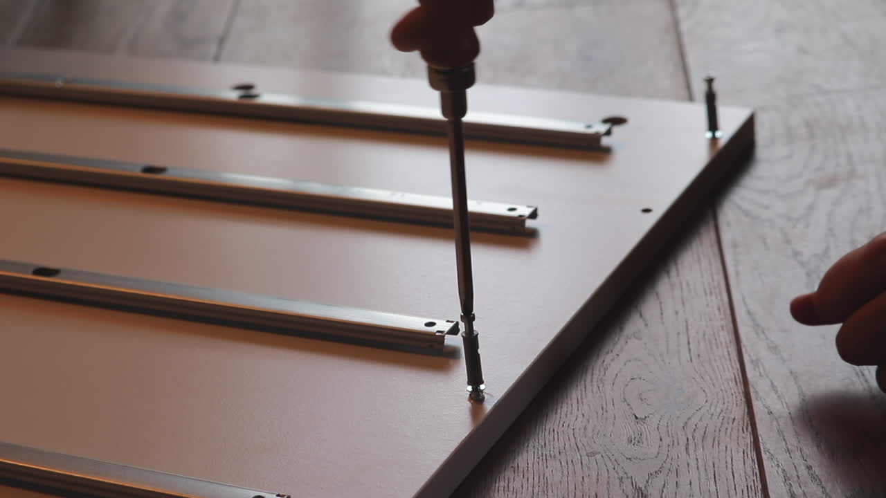 cerrar la mano joven conduce un tornillo en la parte plana del estante, comienza a ensamblar