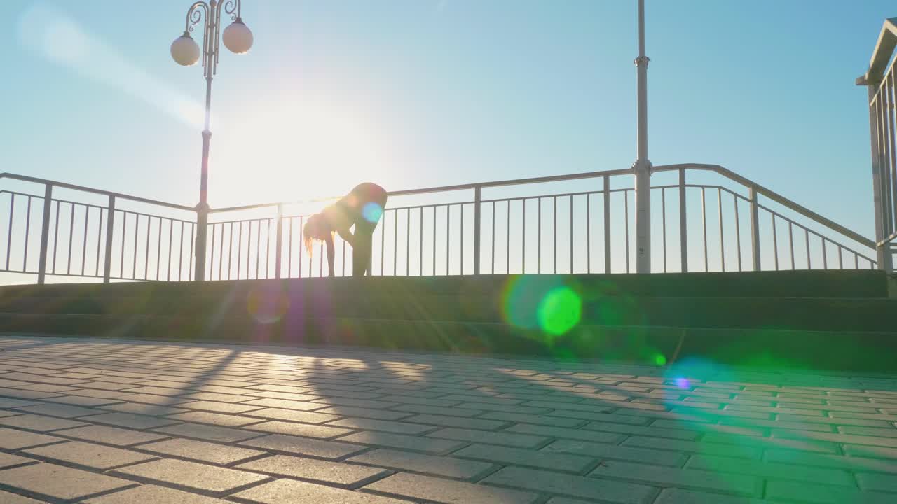 Woman doing yoga outdoors at sunrise