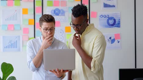 Vorderansicht-Eines-Jungen-Gemischtrassigen-Geschäftsteams,-Das-In-Einem-Modernen-Büro-In-4K-Am-Laptop-Arbeitet