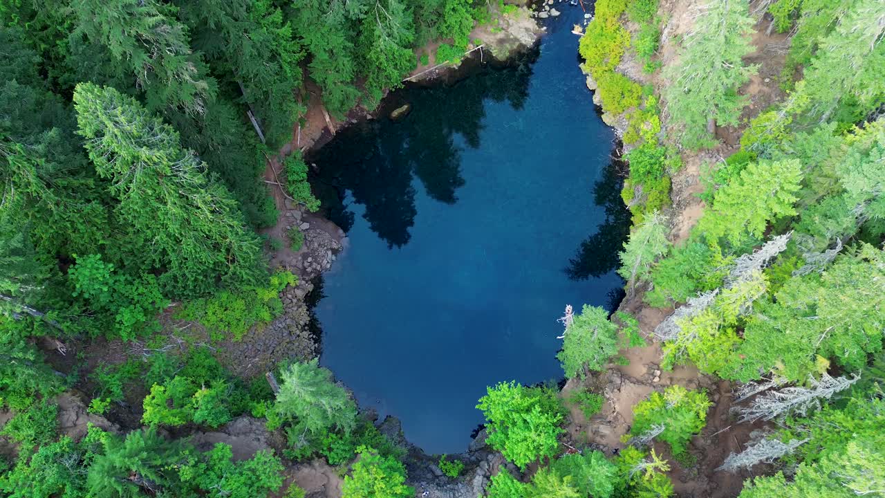 Drone aerial landscape of scenic crystal clear water freezing lake Blue Pool in nature creek forest woodlands of Oregon USA America Tamolitch Falls parks wildlife pine trees travel