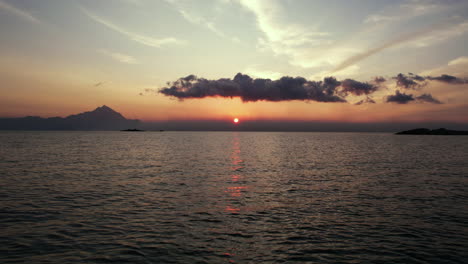 Drone-Shot-of-Sunrise-Above-Sea,-Flying-Low-Above-Water