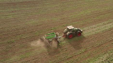 profile follow aerial shot of a tractor ploughing a field