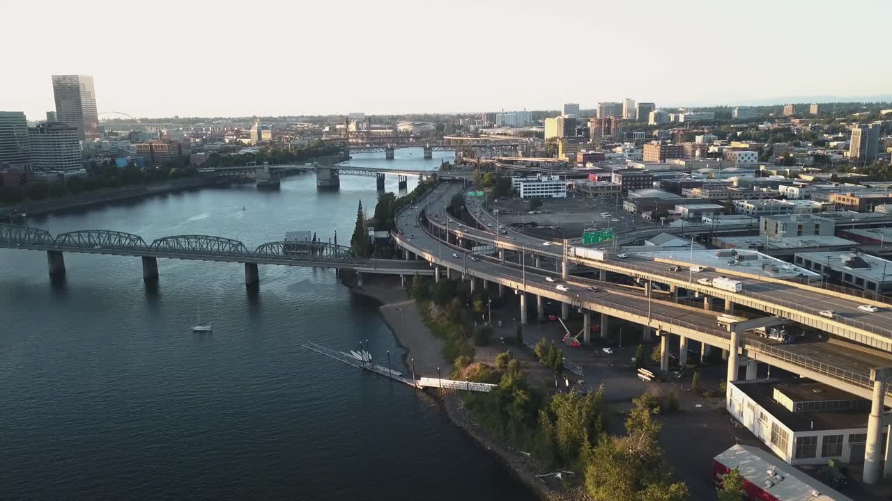 Pan of city in downtown Portland, Oregon with sunset and river.