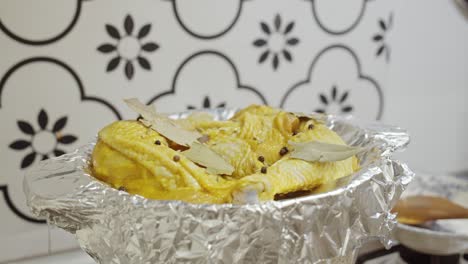 agregando aceite de oliva y cubriendo los muslos de pollo sazonados con papel aluminio