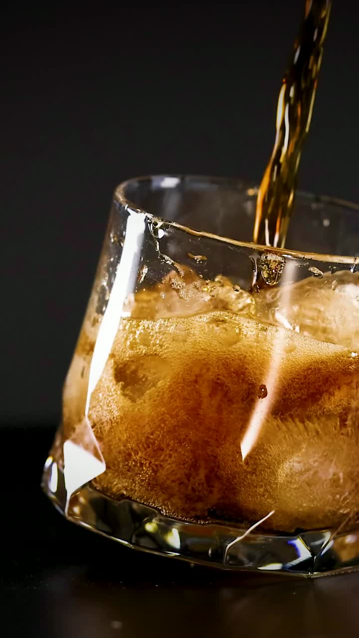cola siendo vertida en un vaso con hielo