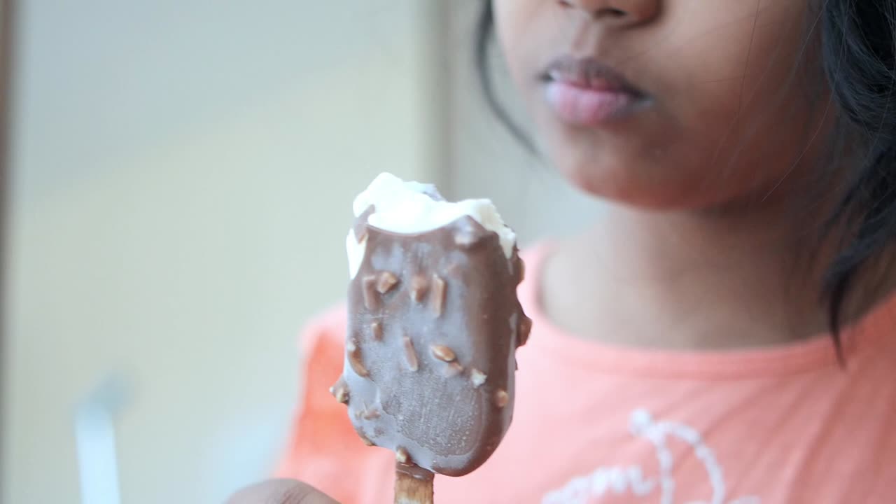 una niña disfruta de un helado de chocolate en un caluroso día de verano