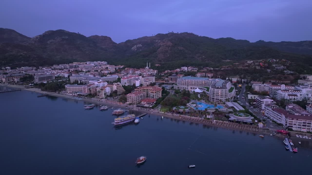 Veduta aerea di barche illuminate dall'alba nel porto di Marmaris e montagne, Turchia