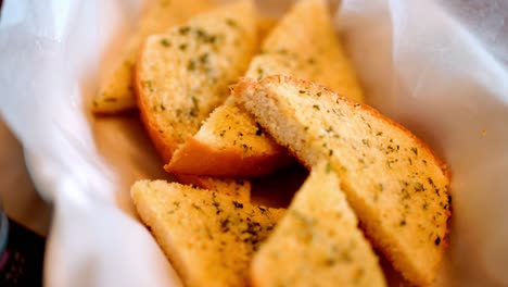 freshly baked garlic bread in basket, white cloth background