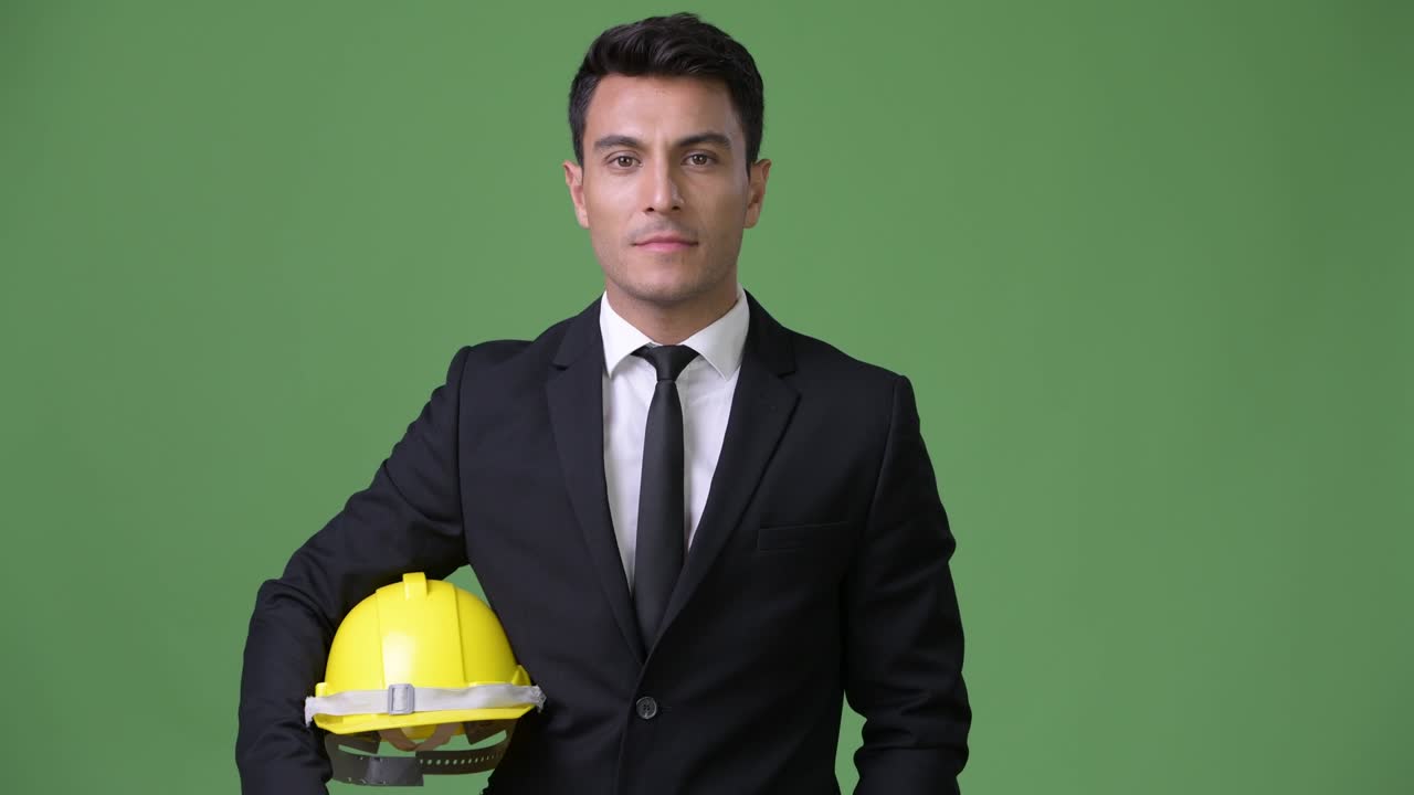 joven y guapo hombre de negocios hispano contra un fondo verde