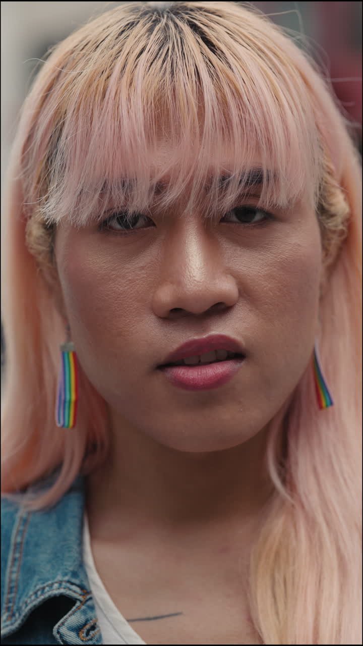 Portrait of a Person with Pink Hair and Rainbow Earrings